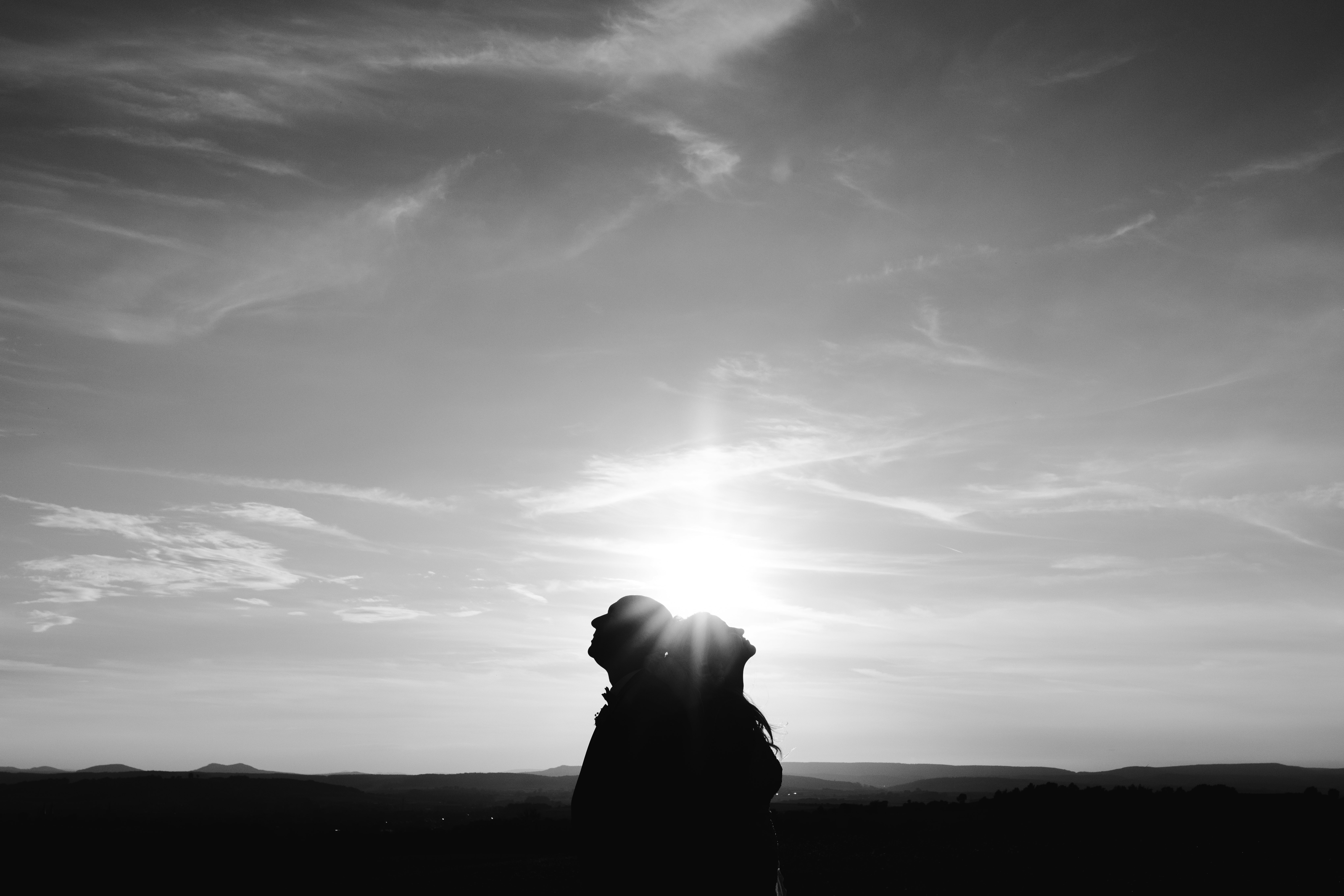 silhouette of man standing under cloudy sky during daytime